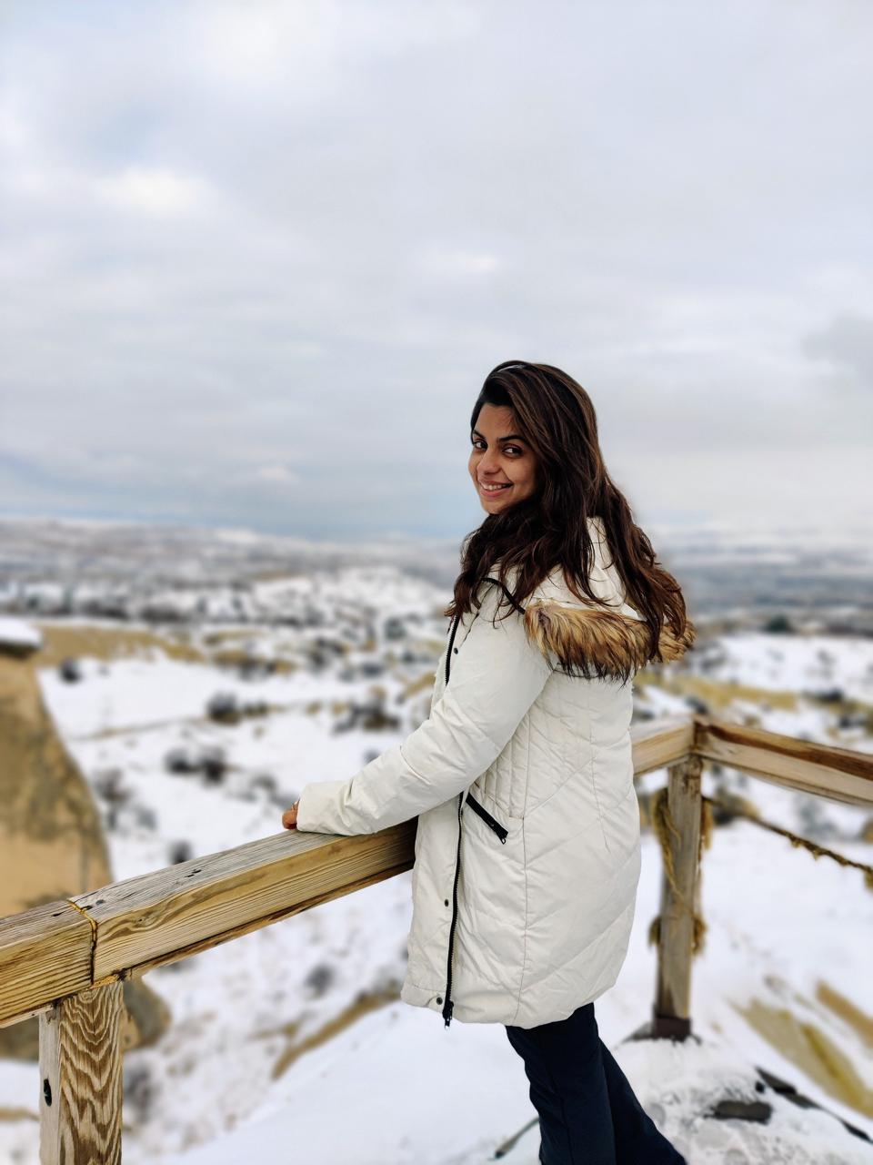 Nikita Thakkar, founder of Yumora, smiling in a snow-covered landscape